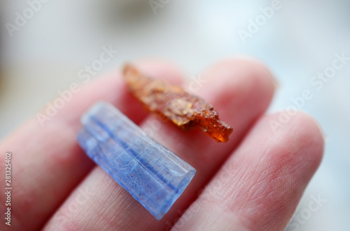 Blue Kyanite and Orange Kyanite on display. Rare Kyanite, bright fresh colors. Orange healing crystal, blue healing crystal. Natural lighting, pastel blue and orange. Witches healing bohemian stones. photo