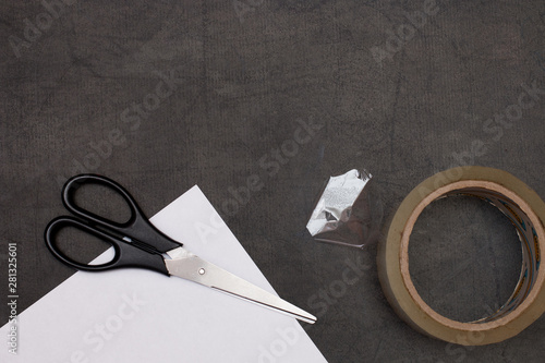 scrissors scotch and white clear paper on the black table backgruond copy space photo