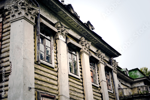 Photography fragment of stucco, windows and columns  of the abandoned ruined Manor wooden house