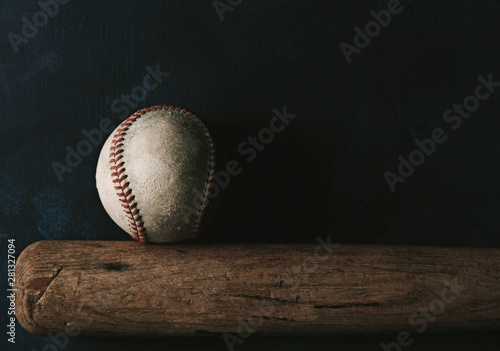 Fotografie, Tablou Baseball sport shows ball with bat on black background, moody and tough sports concept with copy space