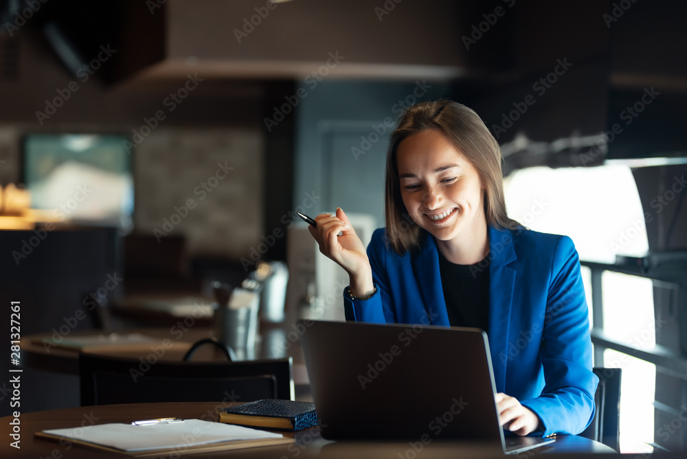 Portrait of a happy business woman with a laptop at a table in a cafe Portrait of a happy business woman with a laptop at a table in a cafe