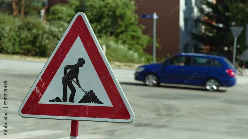 Zlin, Czech Republic - July 2019: Man at work. Temporary traffic sign with defocused cars and people in the background. 4K resolution. Zlin, Czech Republic - July 2019: Man at work. Temporary traffic sign with defocused cars and people in the background. 4K resolution.