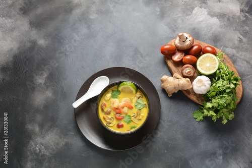 Tom Yam kung Spicy Thai soup with shrimp, seafood,tomatoes, mushrooms, lemongrass, coconut milk, ginger and chili pepper in bowl . Traditional Thai food