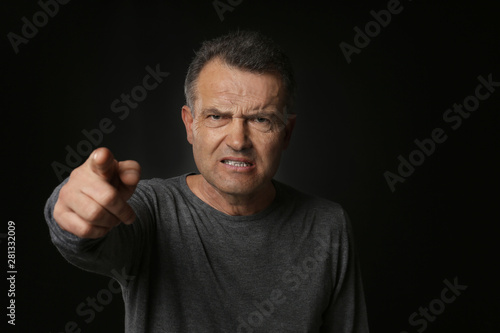Angry mature man pointing a...