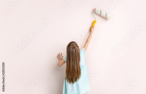 Little girl painting wall i...
