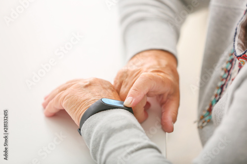 Elderly woman with fitness band checking her pulse  closeup