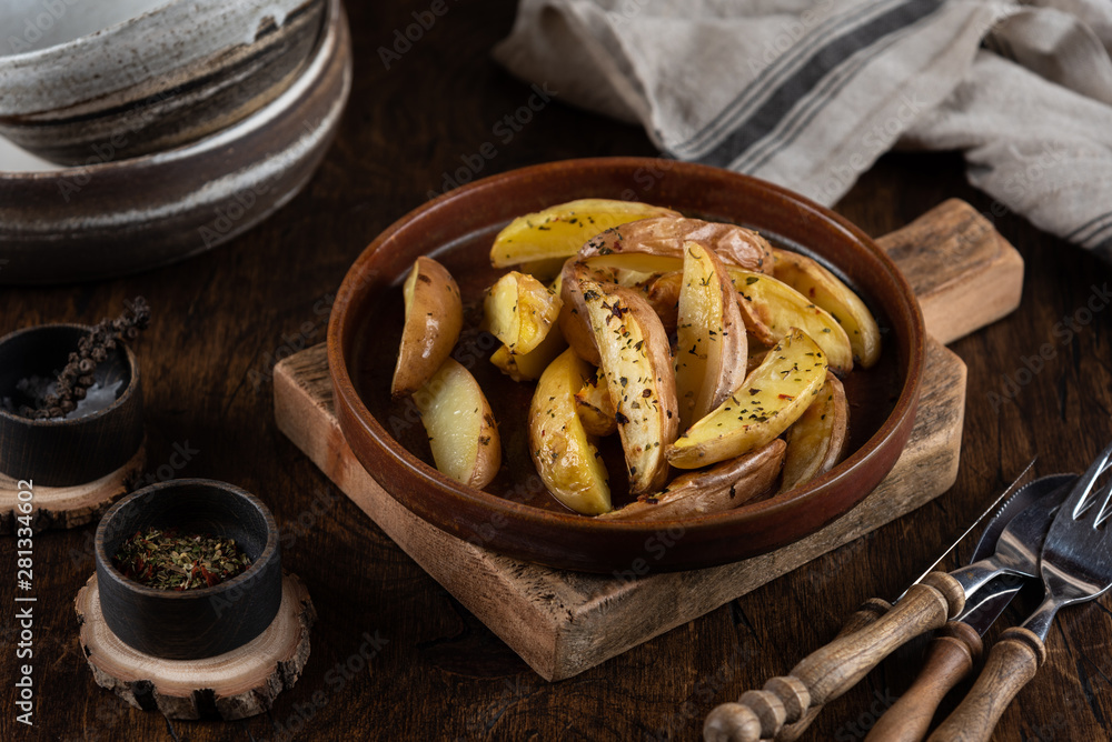 Baked potato in a plate on a wooden background, top view