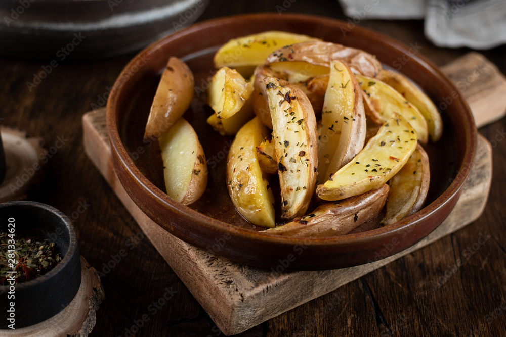 Baked potato in a plate on a wooden background, top view