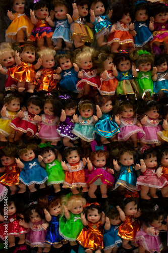 Muñecas de juguete, hechas de plástico y con coloridos vestidos, exhibidas en un típico mercado de mexico
