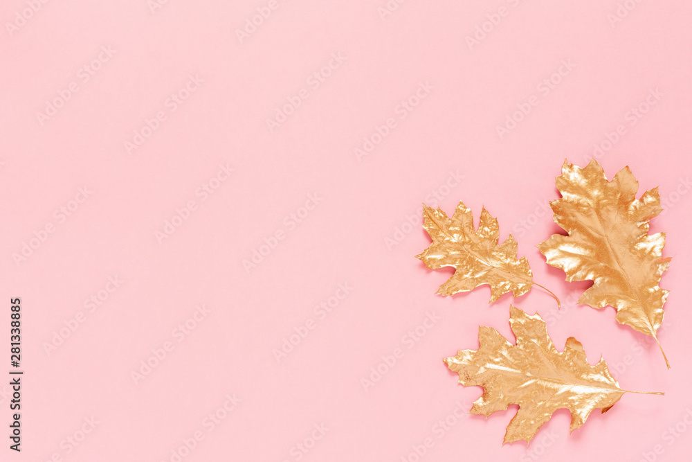 Autumn composition with a gold spray painted natural leaves on pink background. Flat lay, top view, copy space Autumn composition with a gold spray painted natural leaves on pink background. Flat lay, top view, copy space