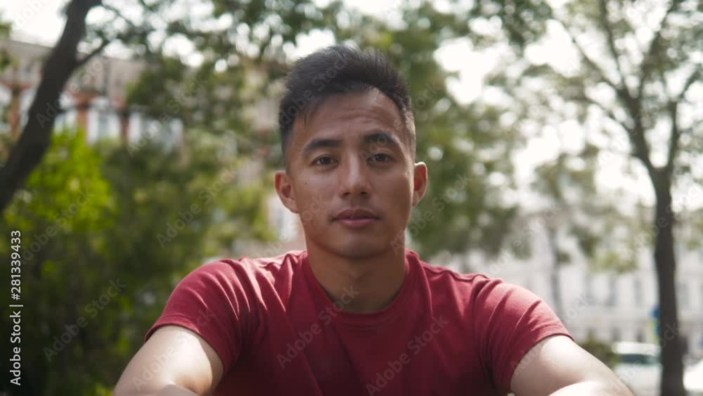 Young Asian man thinking. Portrait of young Asian man thinking outdoor on street, serious korean freelancer in park Young Asian man thinking. Portrait of young Asian man thinking outdoor on street, serious korean freelancer in park