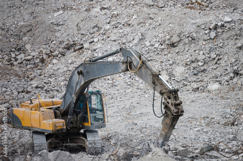 Special hydraulic excavator-destroyer at a construction site, takes apart concrete debris, crushes concrete into small pieces. 