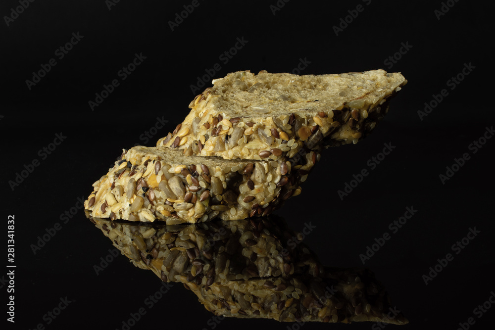 Group of two slices of crispy fresh cereal baguette isolated on black glass