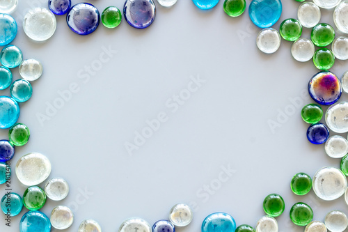 Pattern from colored glass stones on gray background top view mockup