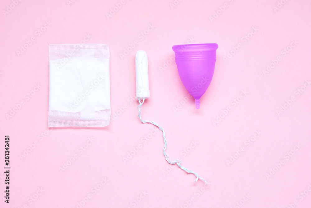 Various sanitary products on pastel pink background. Pad, menstrual cup, tampons. Perion concept. Flat lay, top view. Copy space
