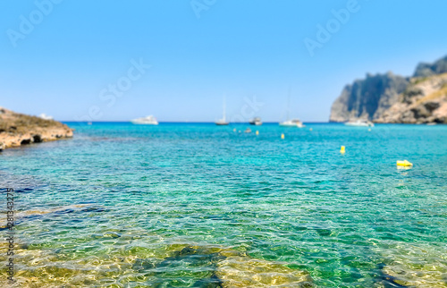 Fototapeta Naklejka Na Ścianę i Meble -  Selective focus, Shallow Transparent water and the beach of Mediterranean Sea on Majorca island