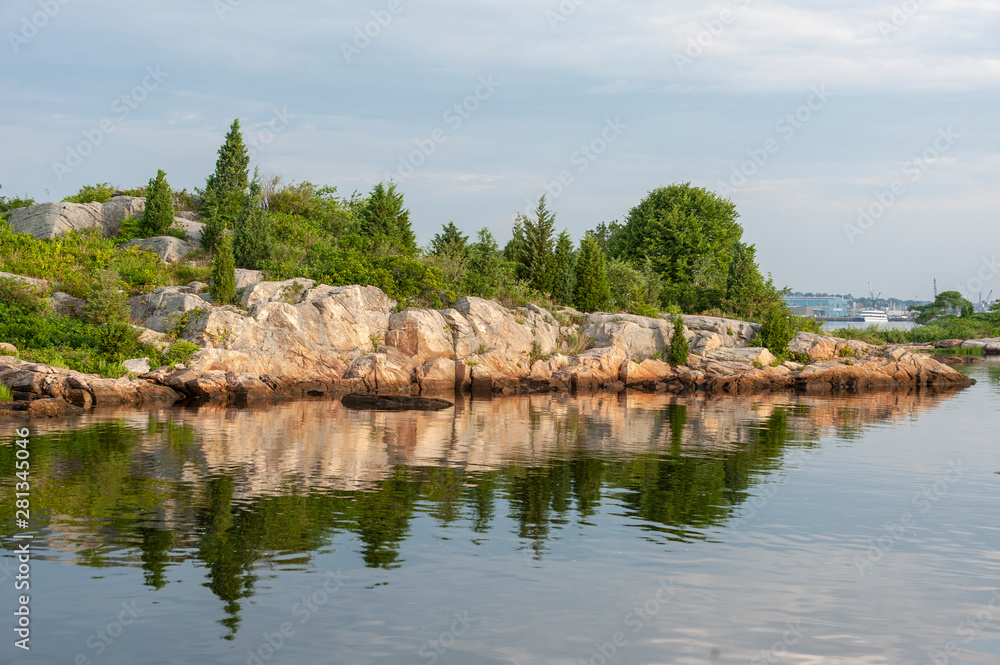 Rocky cliff and trees reflected in Acushnet River Rocky cliff and trees reflected in Acushnet River
