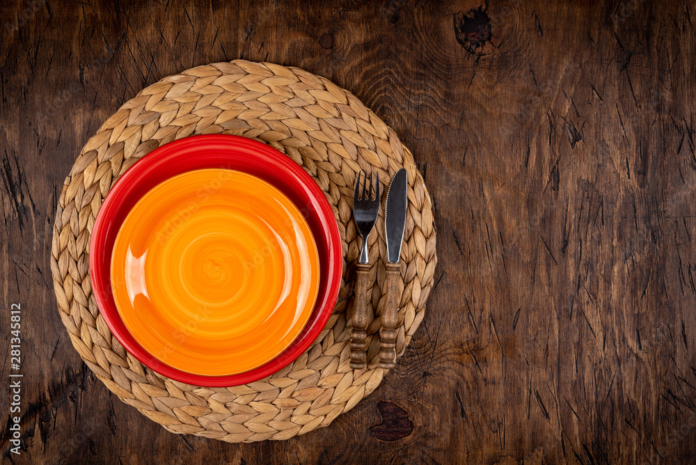 Empty plate with fork and knife on colored wooden background, top view, copy space, mock-up