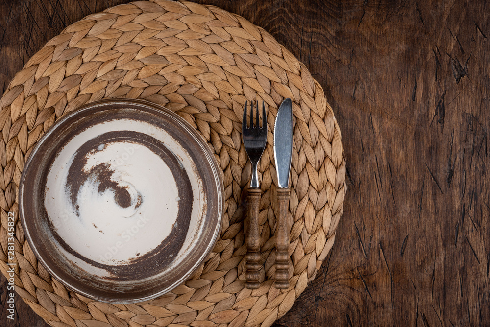 Empty plate with fork and knife on colored wooden background, top view, copy space, mock-up