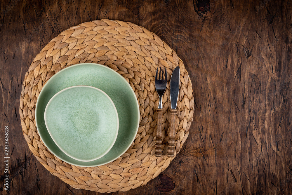 Empty plate with fork and knife on colored wooden background, top view, copy space, mock-up