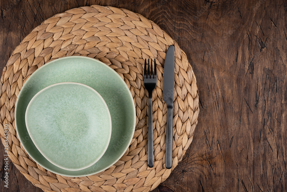 Empty plate with fork and knife on colored wooden background, top view, copy space, mock-up