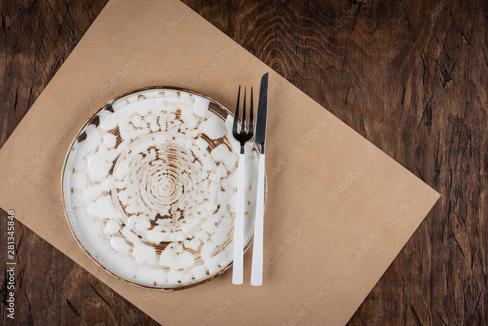 Empty plate with fork and knife on colored wooden background, top view, copy space, mock-up