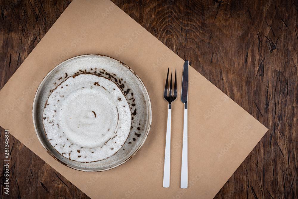 Empty plate with fork and knife on colored wooden background, top view, copy space, mock-up