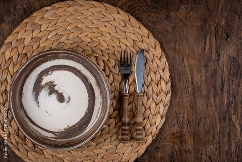 Obraz na płótnie Empty plate with fork and knife on colored wooden background, top view, copy space, mock-up w salonie