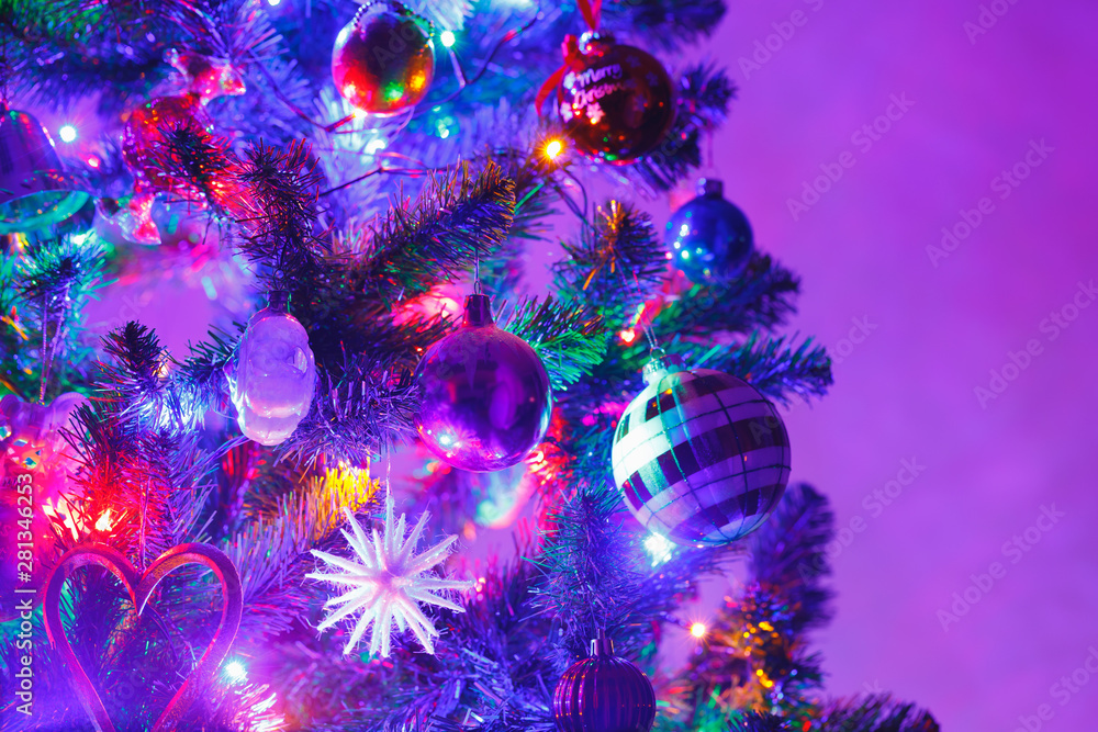 Christmas tree with decorations and purple illumination, close-up view Christmas tree with decorations and purple illumination, close-up view