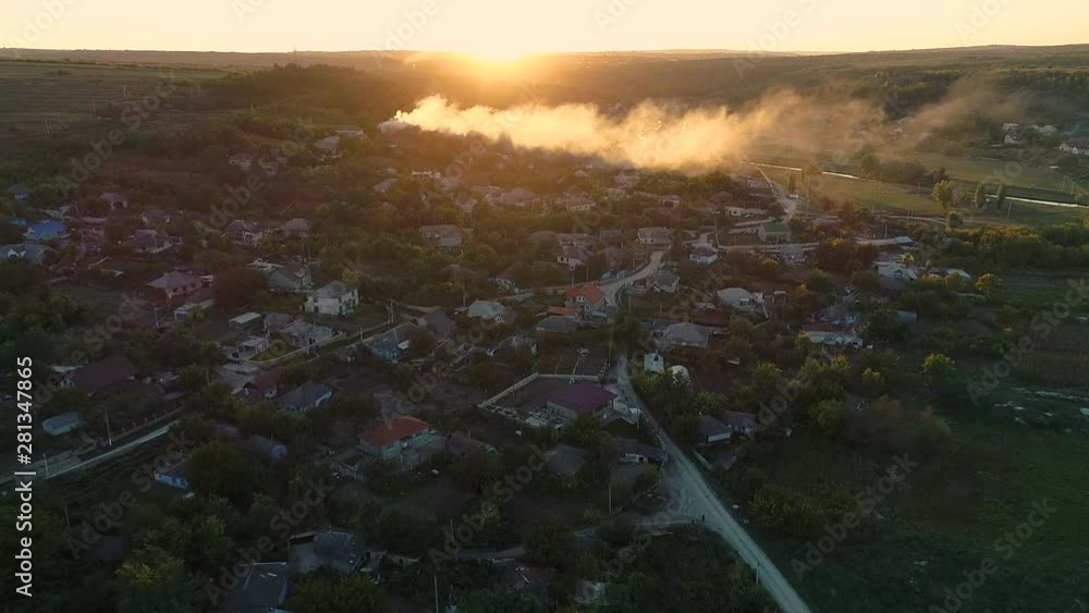 Aerial view of village and a thick smoke coming from a corner, during sunrise. Aerial view of village and a thick smoke coming from a corner, during sunrise.