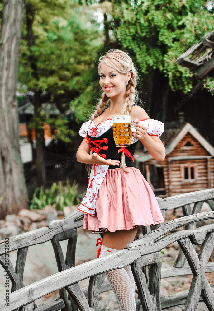 Beautiful caucasian woman with beer in dress. Octoberfest festival.