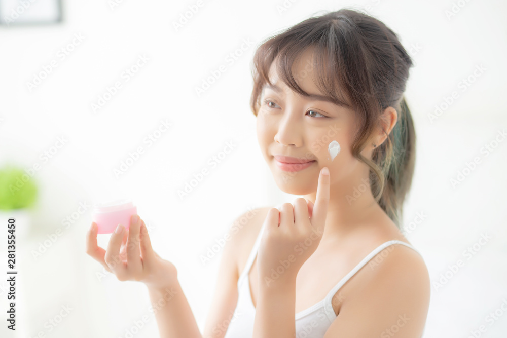 beautiful young asian woman happy applying cream or lotion with moisturizer to skin face, beauty asia girl applying skincare touch facial with cosmetic makeup, healthy and wellness concept. beautiful young asian woman happy applying cream or lotion with moisturizer to skin face, beauty asia girl applying skincare touch facial with cosmetic makeup, healthy and wellness concept.