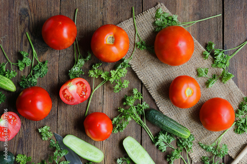 vegetables - tomatoes and cucumbers on a wooden board.