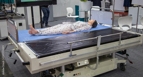 Patient dummy lying on automatic transfer hospital bed