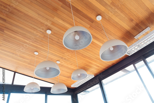 Modern ceiling lamp interior light bulbs against wooden wall background. Ceiling lamps are some of most versatile lamps to decorate with. Modern and contemporary ceiling lights are match every style.