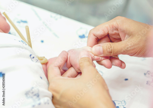 The nurse's hands are on the baby's veins to prepare the injection in a hospital.