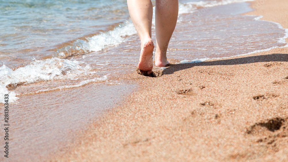 Closeup of bare feet on the beach. Walking on the sand at the water's edge. Vacation and travel concept. Closeup of bare feet on the beach. Walking on the sand at the water's edge. Vacation and travel concept.