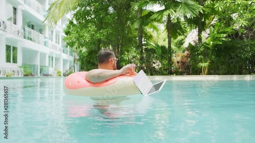 Wallpaper Mural Fat funny man in pink inflatable circle surprised and drops the laptop into the water in the pool. Torontodigital.ca
