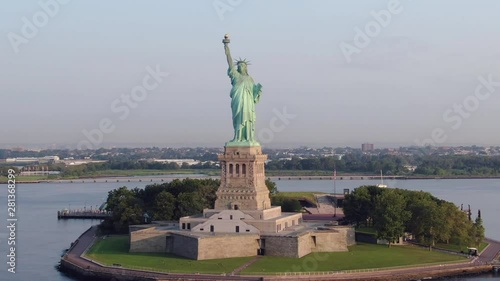 Straight pull away descending aerial Statue of Liberty; cinematic; sunny morning; 4k