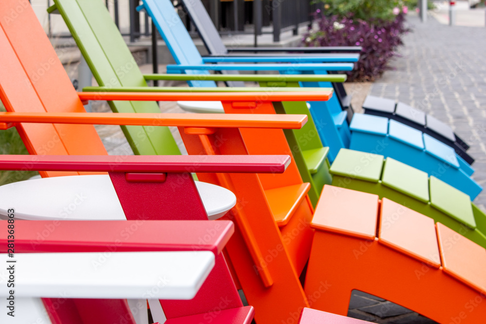 A row of outdoor chairs with a rainbow color scheme