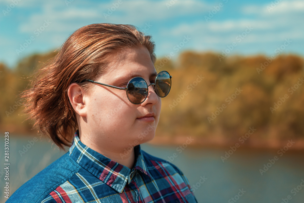 The guy in sunglasses on the background of the river in the summer. The guy in sunglasses on the background of the river in the summer.
