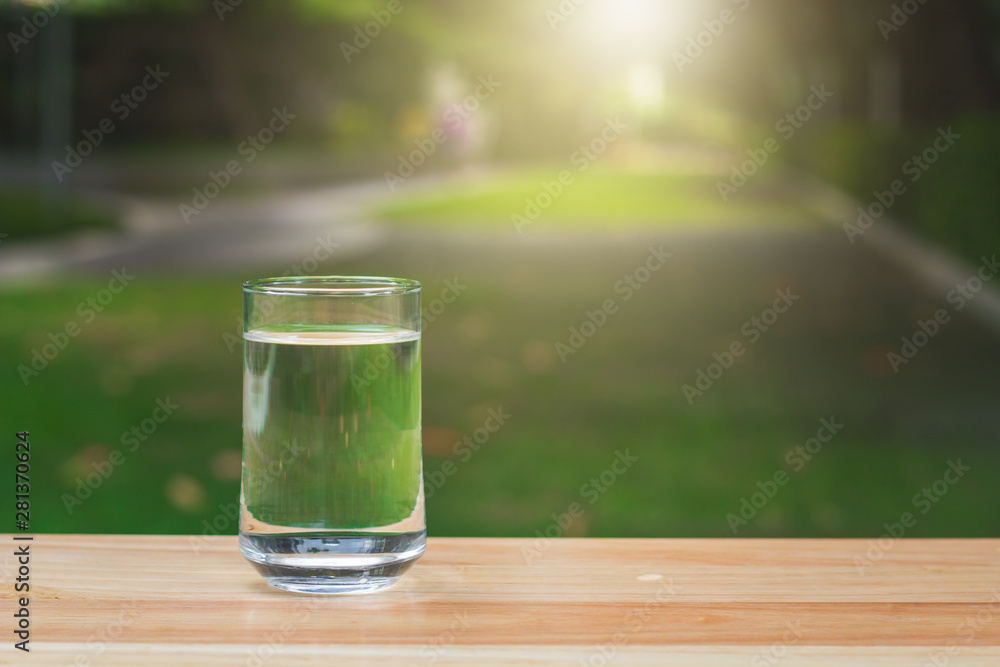 Drink water Purified on table over sunlight and natural green background Drink water Purified on table over sunlight and natural green background