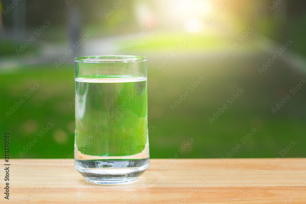 Drink water Purified on table over sunlight and natural green background Drink water Purified on table over sunlight and natural green background