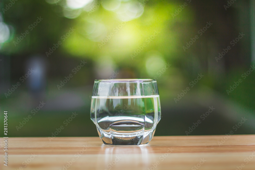 Drink water Purified on table over sunlight and natural green background Drink water Purified on table over sunlight and natural green background