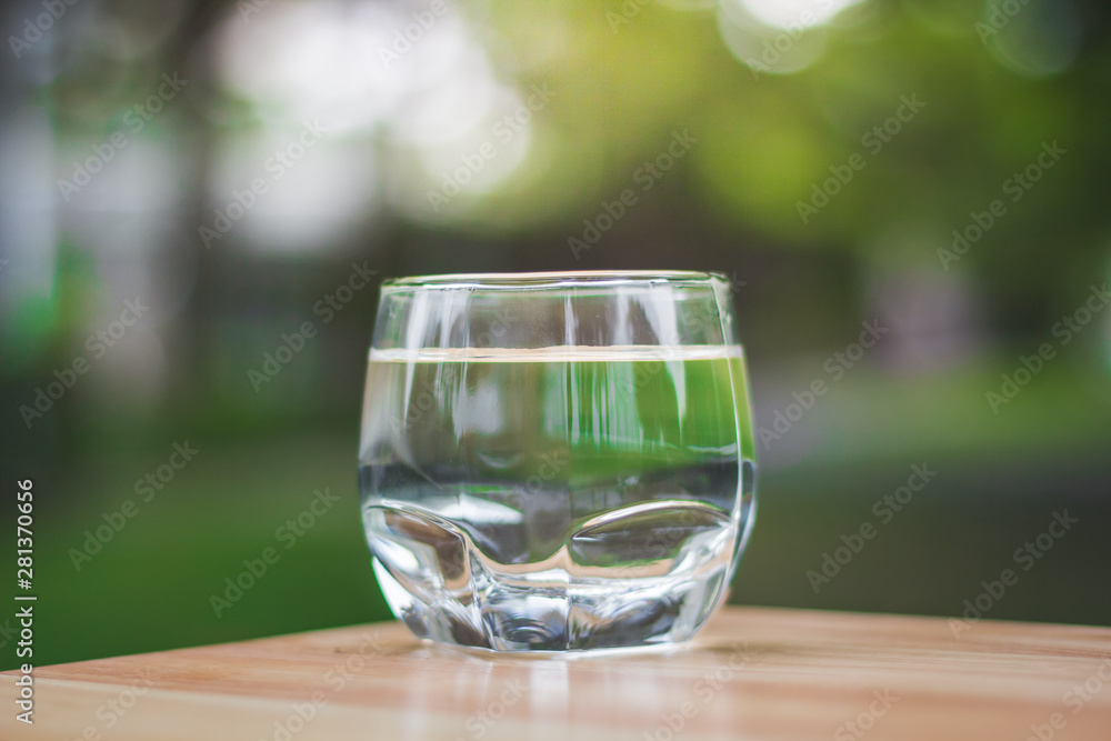 Drink water Purified on table over sunlight and natural green background Drink water Purified on table over sunlight and natural green background