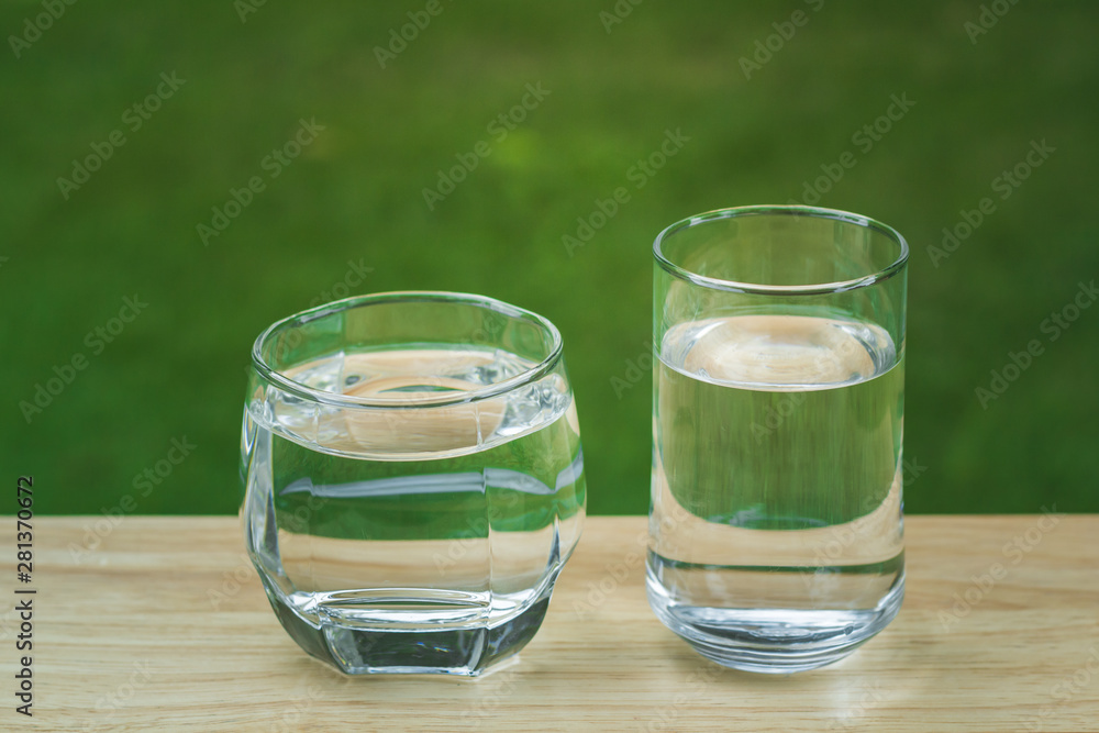 Drink water Purified on table over sunlight and natural green background Drink water Purified on table over sunlight and natural green background