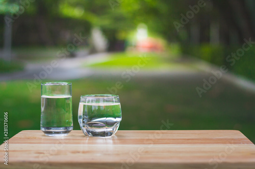 Drink water Purified on table over sunlight and natural green background