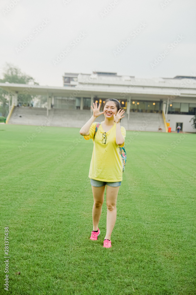 Obraz premium Young girl student having fun on grass field in the afternoon in campus