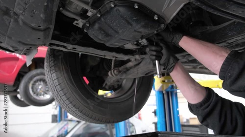 Oil draining from car engine during regular servicing in a work shop