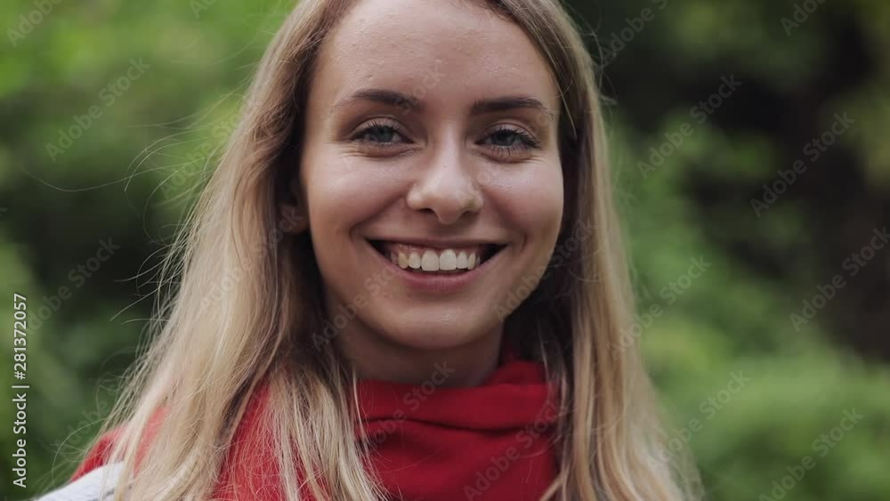 Portrait of Young Beautiful Woman Wearing Red Scarf Inhaling and Exhaling Fresh Air, Taking Deep Breath, Reducing Stress and Looking into the Camera. She is Smiling. Healthy Lifestyle Concept. Portrait of Young Beautiful Woman Wearing Red Scarf Inhaling and Exhaling Fresh Air, Taking Deep Breath, Reducing Stress and Looking into the Camera. She is Smiling. Healthy Lifestyle Concept.
